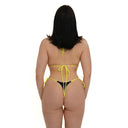 Woman wearing a yellow bikini with black bottom on a white background