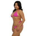Woman wearing a fuchsia pink bikini on a white background, side view