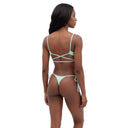 A woman modeling a mint green string bikini from the back, showing the crisscross strap design on the back, against a solid white background.